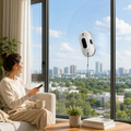 Woman sitting by a large window with a view of a cityscape, using a handheld fan.